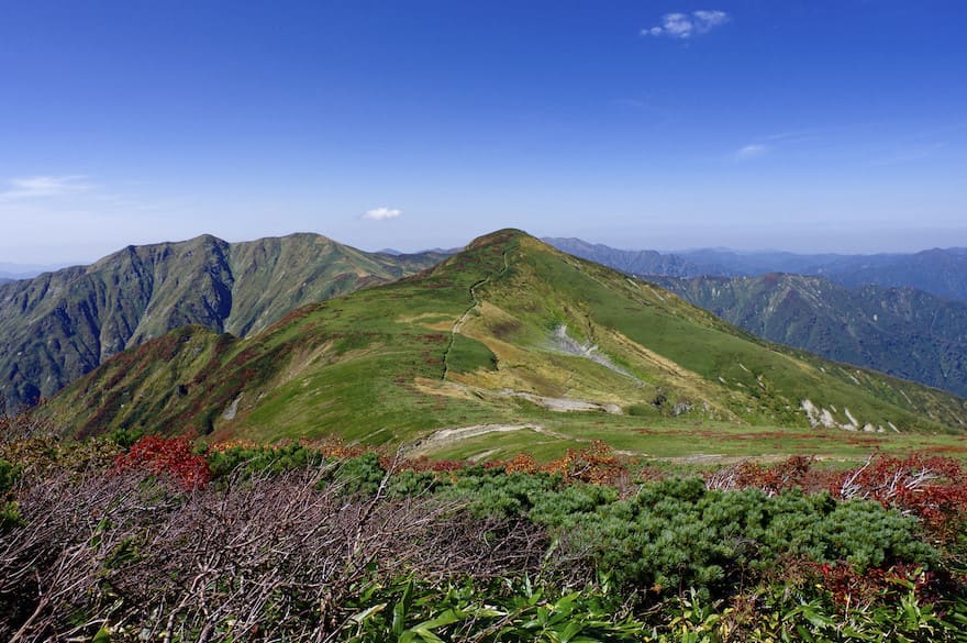 大朝日岳避難小屋とその奥の山々の景色の写真